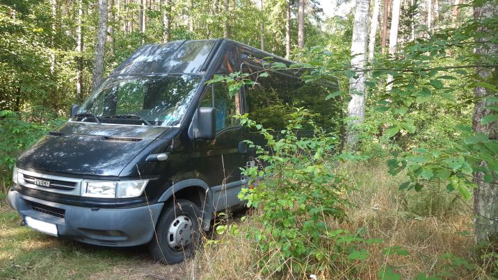 Zdjęcie&#x20;przedstawia&#x20;czarny&#x20;samochód&#x20;&#x28;bus&#x29;&#x20;stojący&#x20;w&#x20;lesie&#x2e;