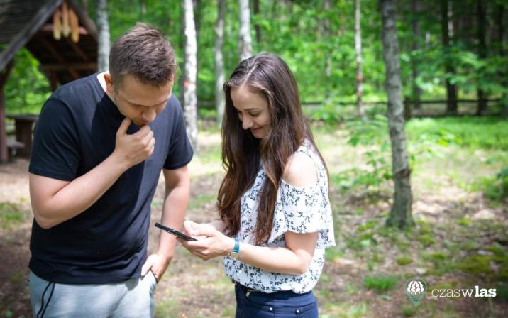 Na&#x20;zdjęciu&#x20;widoczni&#x20;sa&#x20;turyści&#x20;w&#x20;lesie&#x20;przeglądający&#x20;stronę&#x20;czaswlas&#x2e;pl&#x20;na&#x20;smartfonie&#x2e;&#x2f;Fot&#x2e;&#x20;Filip&#x20;Kaczanowski&#x2c;&#x20;Lasy&#x20;Państwowe