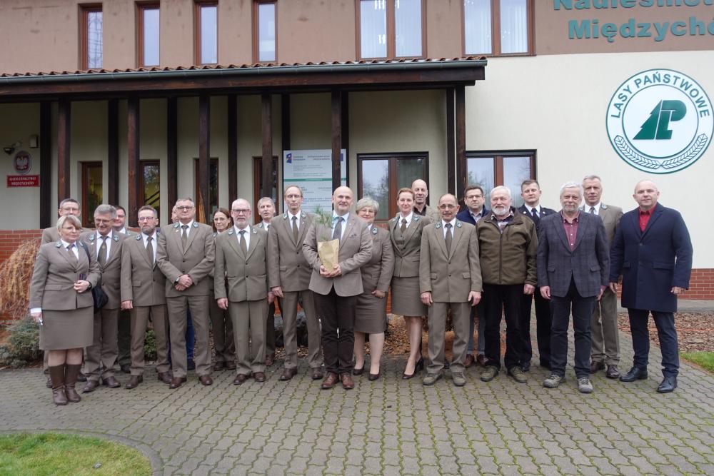 Zdjęcie przedstawia  uczestników spotkania Rady LKP stojących przed siedzibą Nadleśnictwa  Międzychód